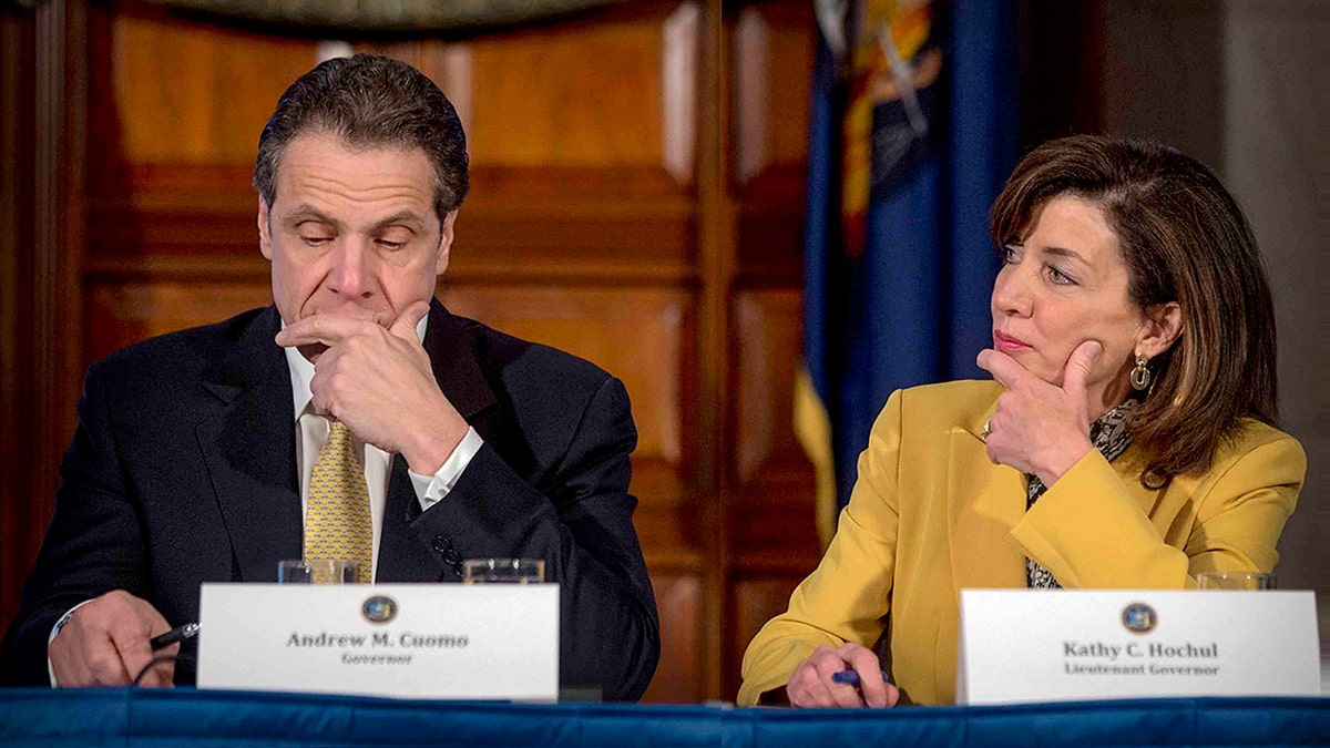 Andrew Cuomo sit next to Kathy Hochul