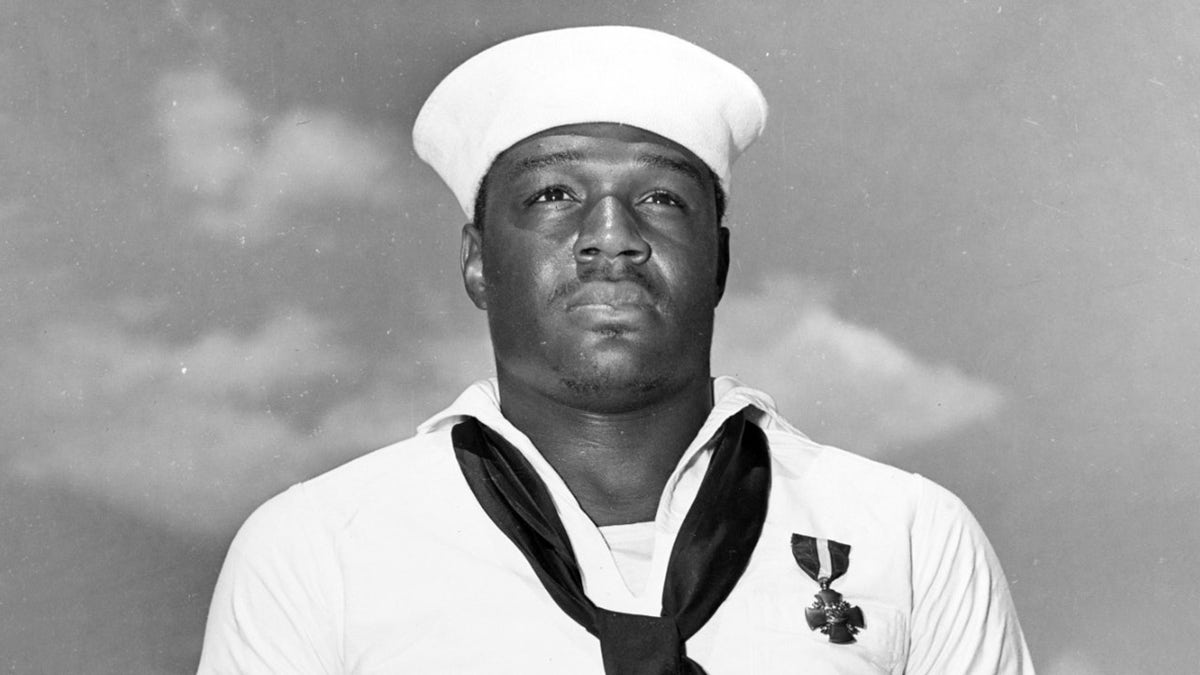 After being presented with the Navy Cross by Admiral Chester W. Nimitz, on board USS Enterprise (CV-6) at Pearl Harbor, 27 May 1942. The medal was awarded for heroism on board USS West Virginia (BB-48) during the Pearl Harbor Attack, 7 December 1941. Official U.S. Navy Photograph, now in the collections of the National Archives.