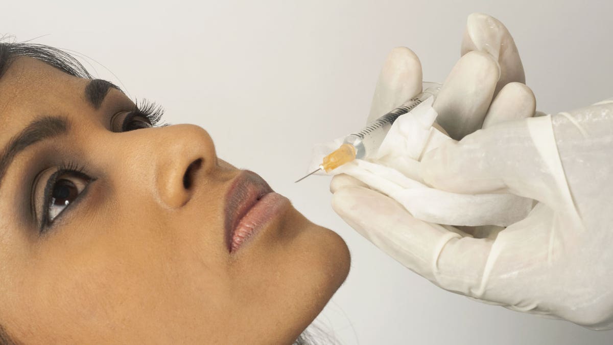 A woman receives lip injections