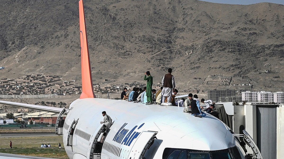 People sitting on top of an aircraft in Afghanistan