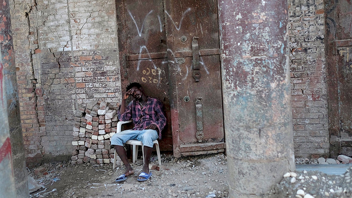 A man sits in front of a damaged building in Jeremie, Haiti, Wednesday, Aug. 18, 2021, four days after the city was struck by a 7.2-magnitude earthquake. (AP Photo/Matias Delacroix)