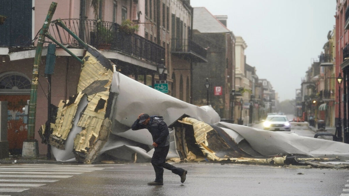 A man passes by a section of roof that was blown off of a building in the French Quarter by Hurricane Ida winds, Sunday, Aug. 29, 2021, in New Orleans.?