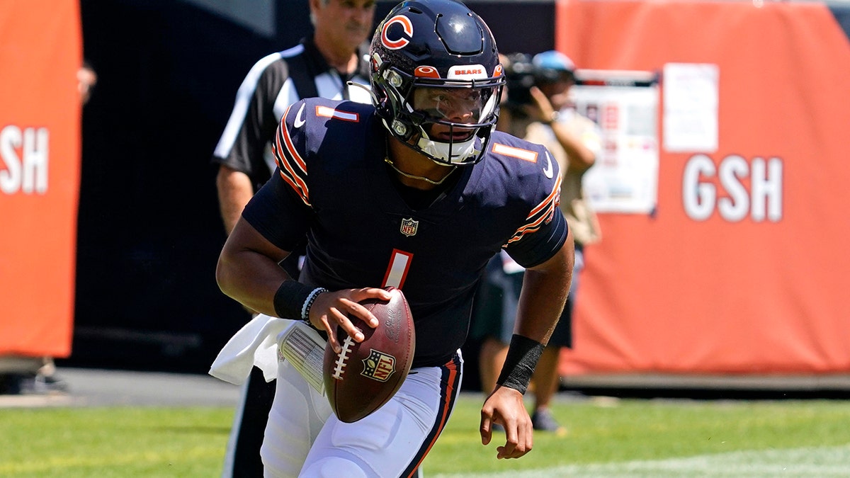 Chicago Bears quarterback Justin Fields runs with the ball during the first half of an NFL preseason football game against the Miami Dolphins in Chicago, Saturday, Aug. 14, 2021. 