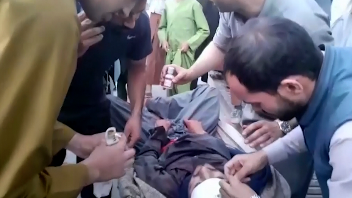 In this frame grab from video, people attend to a wounded man near the site of a deadly explosion outside the airport in Kabul, Afghanistan, Thursday, Aug. 26, 2021. Two suicide bombers and gunmen have targeted crowds massing near the Kabul airport, in the waning days of a massive airlift that has drawn thousands of people seeking to flee the Taliban takeover of Afghanistan. (AP Photo)