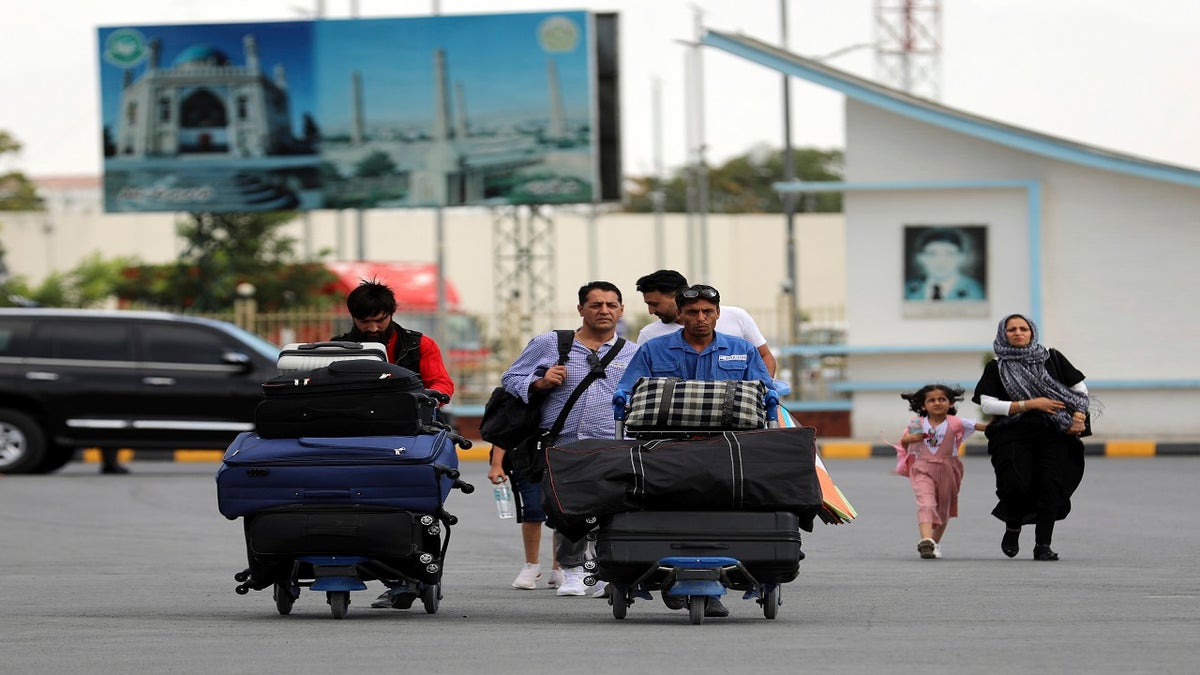 Passengers walk to the departures terminal of Hamid Karzai International Airport in Kabul, Afghanistan, on Saturday. (AP)