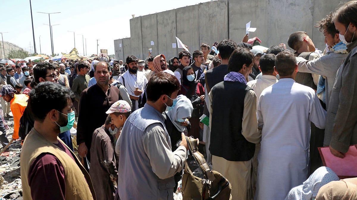 Hundreds of people, some holding documents