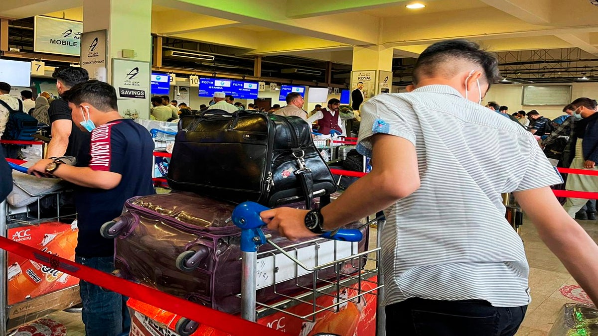 Passengers trying to fly out of Kabul International Airport amid the Taliban offensive wait in line on Friday. (AP)