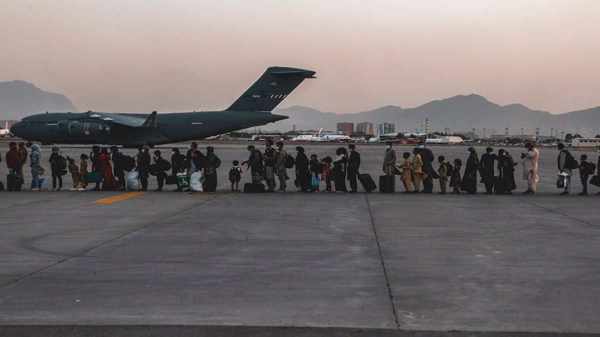 In this image provided by the U.S. Marine Corps, evacuees wait to board a Boeing C-17 Globemaster III, at Hamid Karzai International Airport, Kabul, Afghanistan, on Monday. (AP/Sgt. Isaiah Campbell/U.S. Marine Corps)