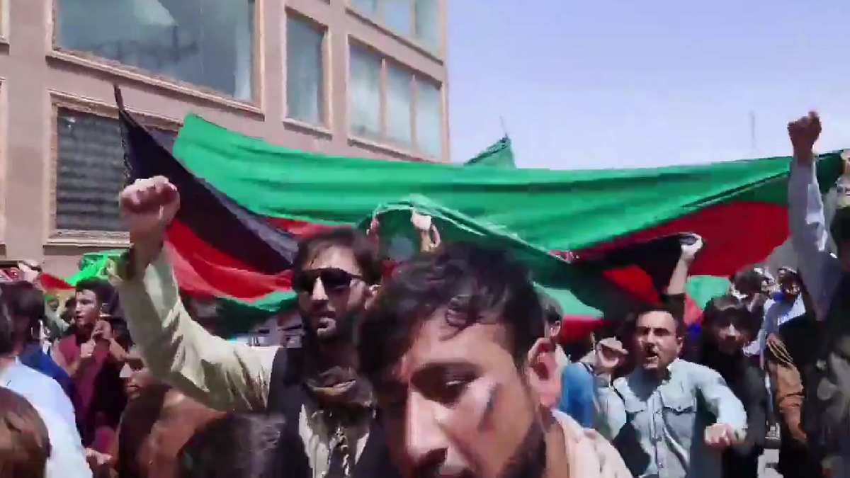 Demonstrators are seen marching in Kabul on Thursday, waving the Afghanistan flag.