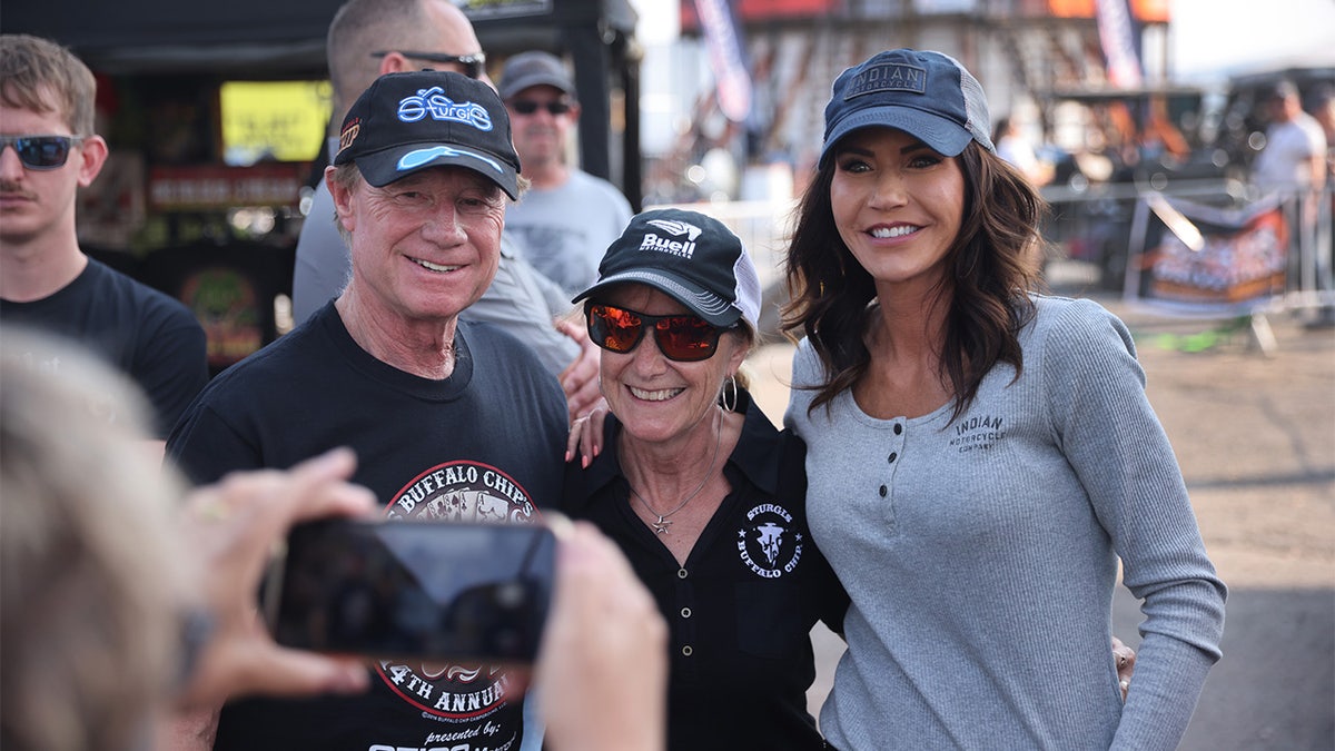 STURGIS, SOUTH DAKOTA - AUGUST 09: Governor Kristi Noem of South Dakota (R) poses for pictures at the Sturgis Buffalo Chip campground after riding in the Legends Ride for charity on August 09, 2021 near Sturgis, South Dakota. (Photo by Scott Olson/Getty Images)
