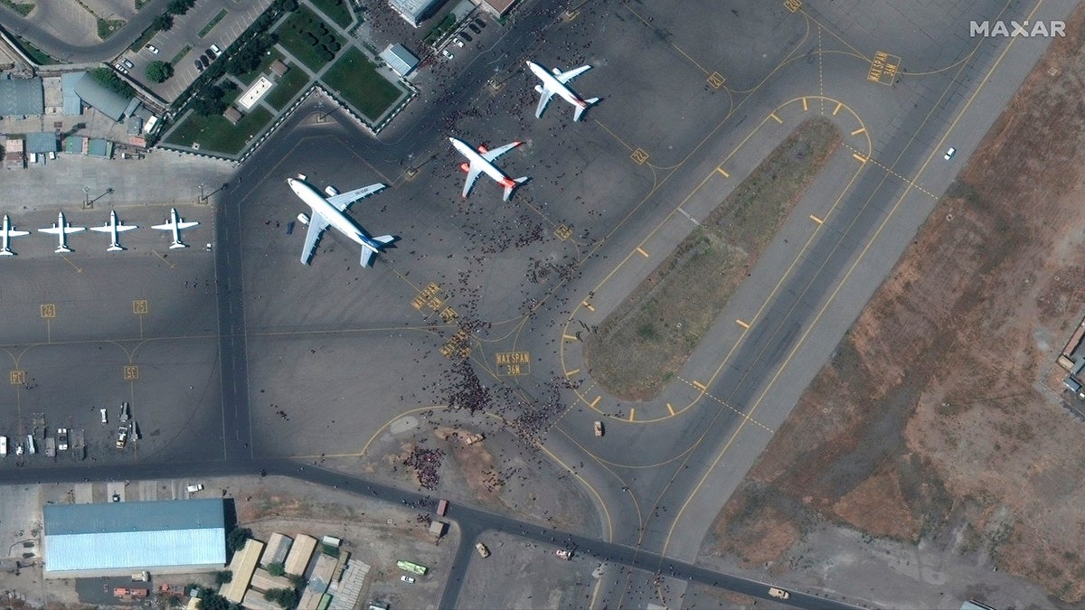 This satellite photo from Maxar Technologies shows swarms of people on the tarmac at Kabul International Airport on Monday. (AP/Maxar Technologies)