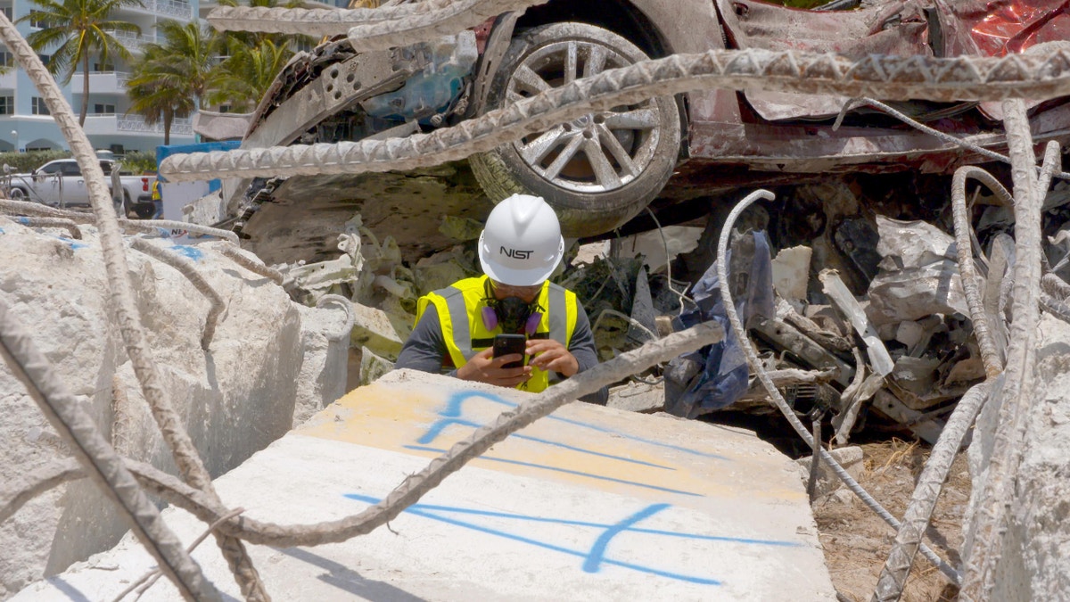 In this July 1, 2021, photo NIST staff members examine pieces of concrete removed from the debris pile at the site of the Champlain Towers South building partial collapse. (Credit: NIST)