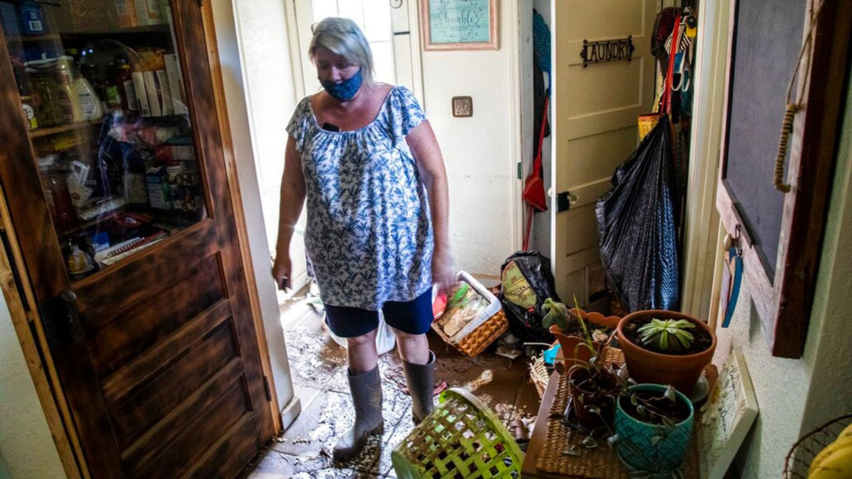 Donella Pressley looks over the flood damage to her home Thursday, Aug. 19, 2021 in Bethel , N.C., after remnants from Tropical Storm Fred caused flooding in parts of Western North Carolina Tuesday.