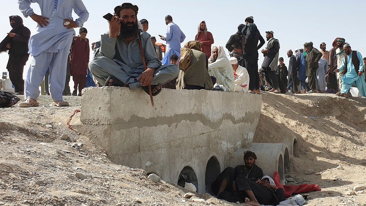 Stranded people wait for the reopening of the border crossing point which was closed by the authorities, in Chaman on August 7, 2021, after the Taliban took control of the Afghan border town in a rapid offensive across the country. (Photo by Asghar ACHAKZAI / AFP) (Photo by ASGHAR ACHAKZAI/AFP via Getty Images)