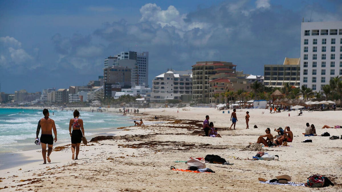 Tourists enjoy the beach in Cancun, Quintana Roo State, Mexico, Wednesday, Aug. 18, 2021. 