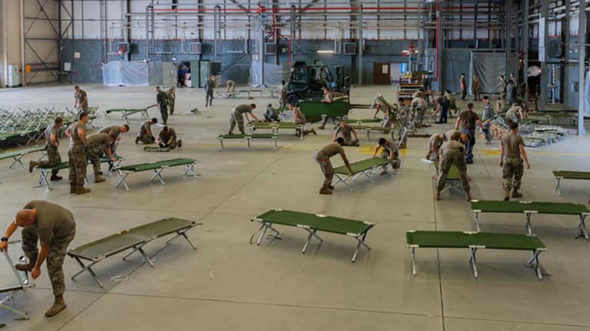 U.S. military personnel and volunteers prepare cots for arriving evacuees at Ramstein Air Base in Germany. (Ramstein Air Base)