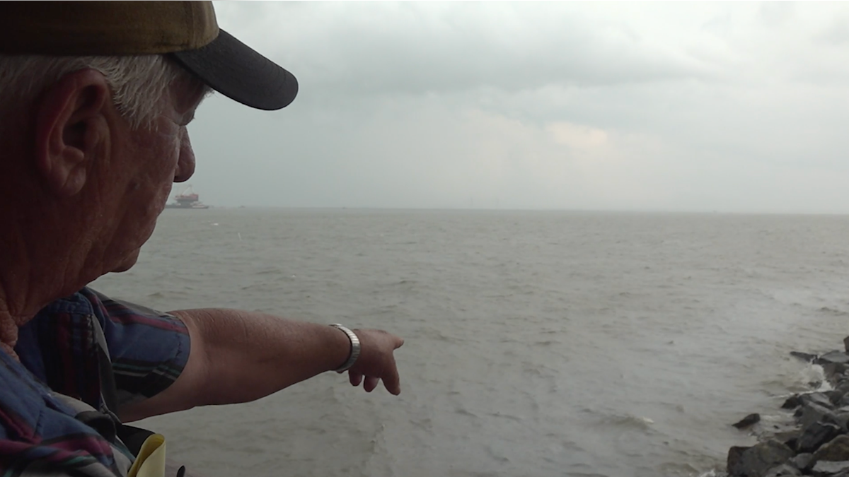 Dennis Brown points into the St. Simon sound where oil is leaking from the Golden Ray. (Jayla Whitfield/FNC)