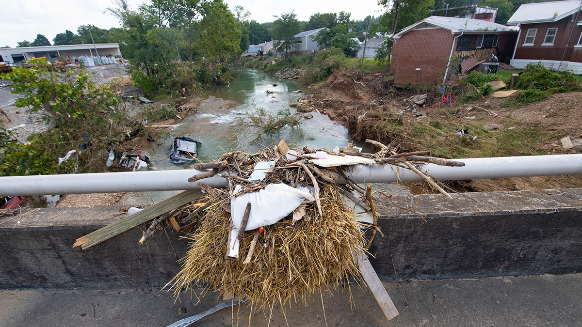 Debris caught on top of a bridge shows how high water reached as cars washed into the creek after recent flooding, Monday, Aug. 23, 2021, in Waverly, Tenn. Heavy rains caused flooding in Middle Tennessee days earlier and have resulted in multiple deaths, and missing people as homes and rural roads were also washed away. 