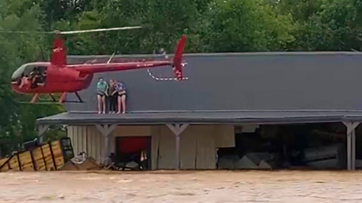 This image from video provided by Jeani Rice-Cranford shows Nashville-based helicopter pilot Joel Boyers rescuing people from a rooftop, Saturday, Aug. 21, 2021 in Waverly, Tenn. Boyers, who co-owns Helistar Aviation, said he ended up rescuing 17 people that day. He’s proud of that, but said he’s the one who should be thanking them.
