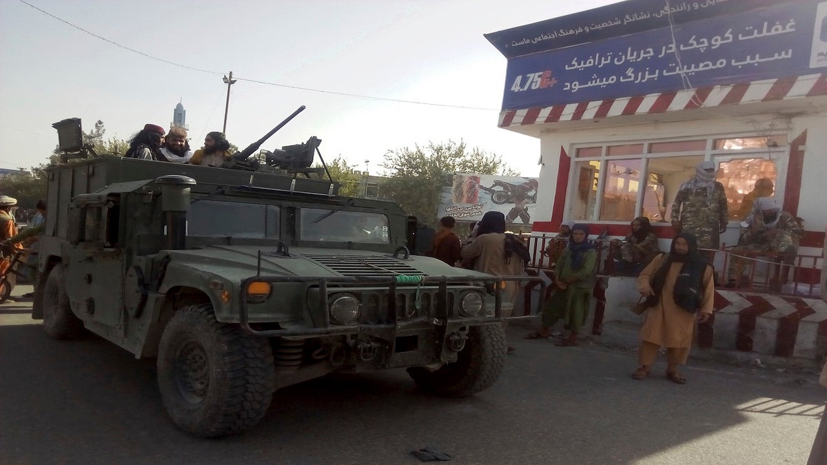 Taliban fighters stand guard at a checkpoint in Kunduz city, northern Afghanistan, on Monday. (AP)