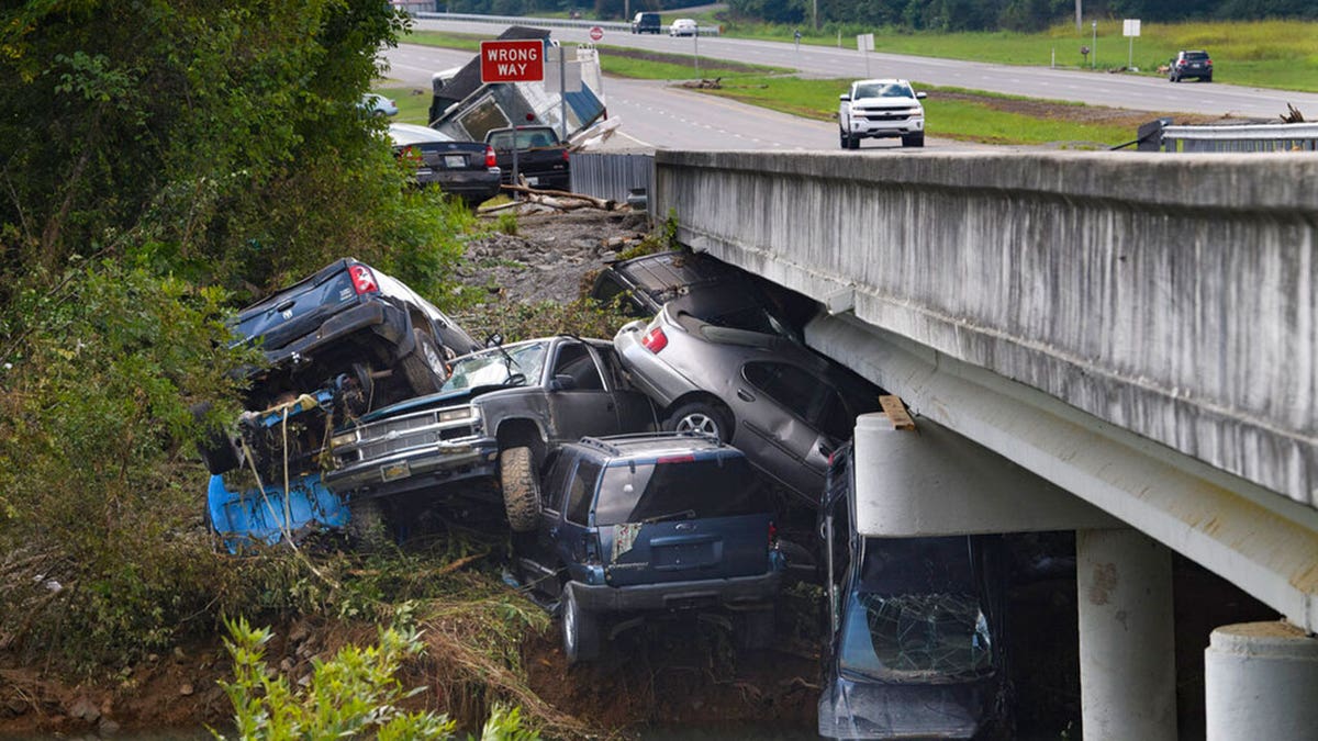 Cars are stacked on top of each other on the banks of Blue Creek being swept up in flood water, Monday, Aug. 23, 2021, in Waverly, Tenn. Heavy rains caused flooding in Middle Tennessee days ago and have resulted in multiple deaths as homes and rural roads were washed away.?