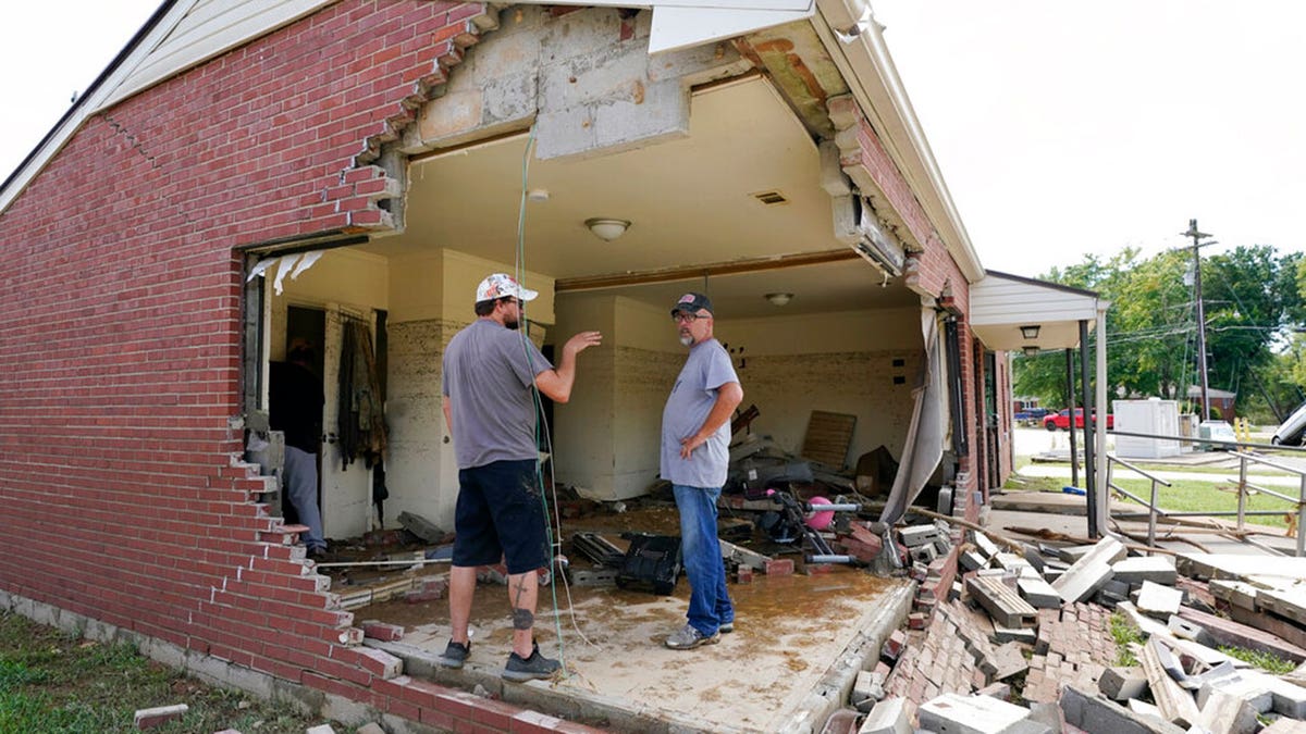 Brian Mitchell, right, looks through the damaged home of his mother-in-law along with family friend Chris Hoover, left, Sunday, Aug. 22, 2021, in Waverly, Tenn. Heavy rains caused flooding Saturday in Middle Tennessee and have resulted in multiple deaths as homes and rural roads were washed away. 