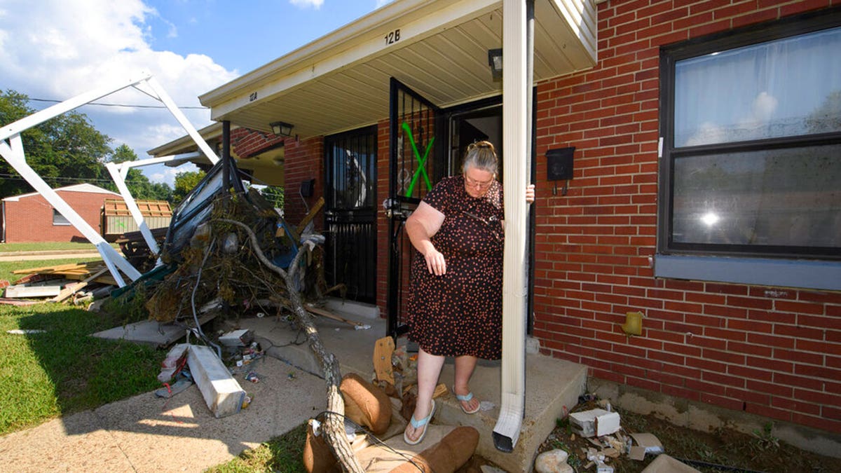 Annie Rushing steps off her porch after it flooded forcing her into a shelter, Monday, Aug. 23, 2021, in Waverly, Tenn. Heavy rains caused flooding in Middle Tennessee days ago and have resulted in multiple deaths, and missing people as homes and rural roads were also washed away. 
