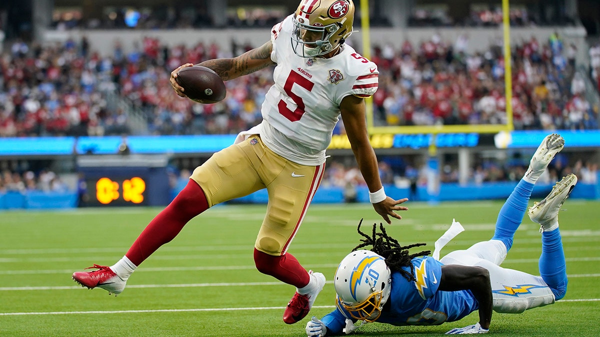 San Francisco 49ers quarterback Trey Lance (5) runs around Los Angeles Chargers defensive back Tevaughn Campbell (20) on a a failed two-point conversion attempt during the first half of a preseason NFL football game Sunday, Aug. 22, 2021, in Inglewood, Calif. (AP Photo/Ashley Landis)
