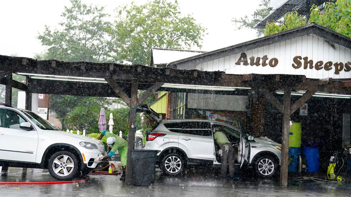 People wash and dry cars near Atlanta, while Tropical Storm Fred makes its way through north and central Georgia on Tuesday, Aug. 17, 2021. 