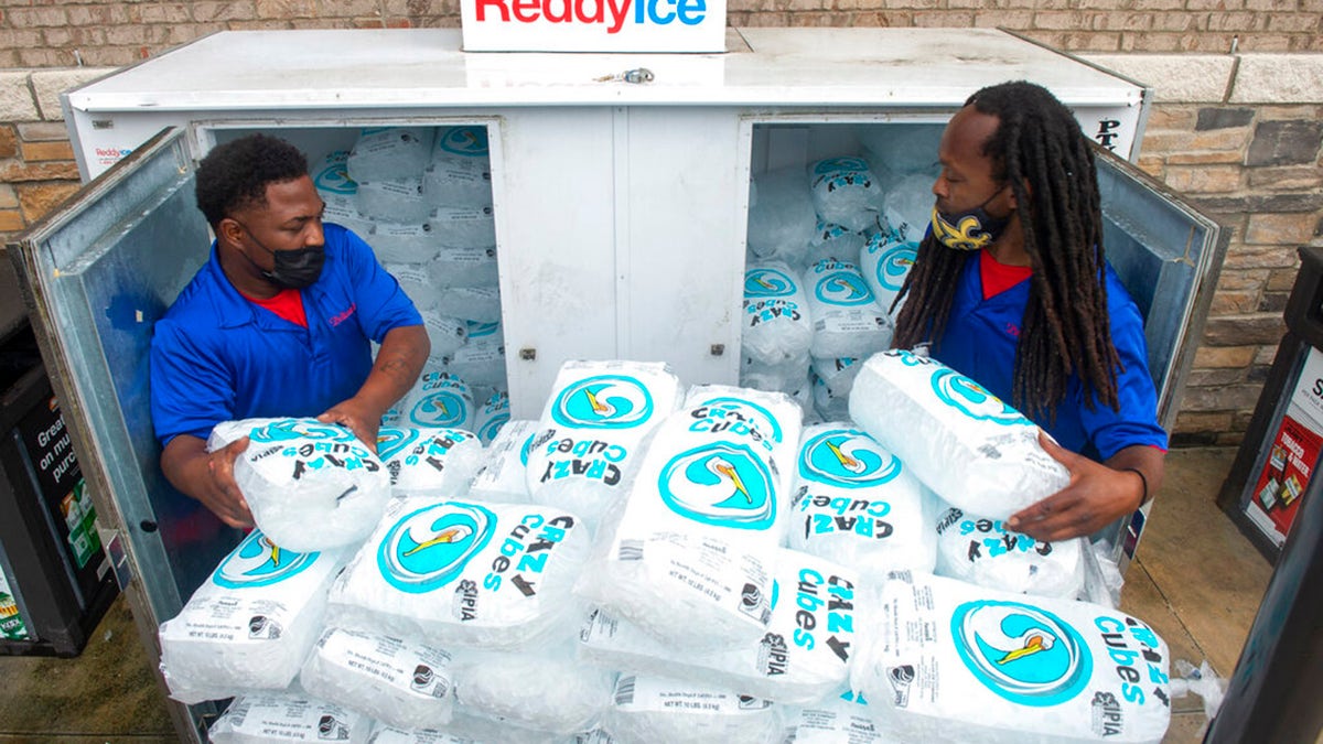 Corey Williams, right, and John Smith, both of Pelican Ice, hurriedly stack bags of ice into a gas station freezer in preparation for Tropical Storm Ida on Friday, Aug. 27, 2021 in Jefferson, La. Forecasters now say Ida could be a major Category 3 hurricane with top winds of 115 mph when it nears the U.S. coast.