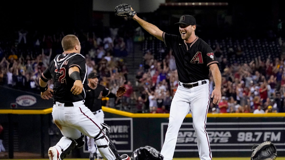 Arizona Diamondbacks starting pitcher Tyler Gilbert, right, celebrates after his no-hitter in a baseball game against the San Diego Padres with catcher Daulton Varsho, Saturday, Aug. 14, 2021, in Phoenix. It was Gilbert's first career start. The Diamondbacks won 7-0. (AP Photo/Matt York)