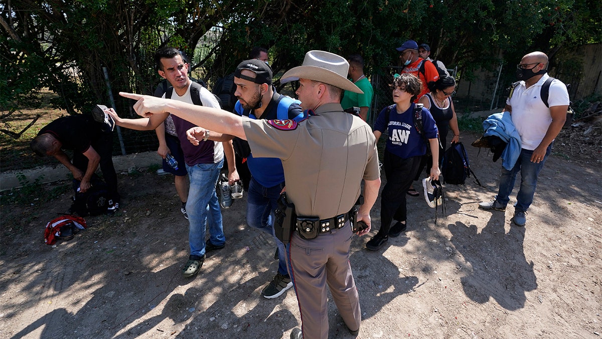 June 16, 2021: A Texas Department of Public Safety officer in Del Rio, Texas directs a group of migrants who crossed the border and turned themselves in. (AP Photo/Eric Gay, File)