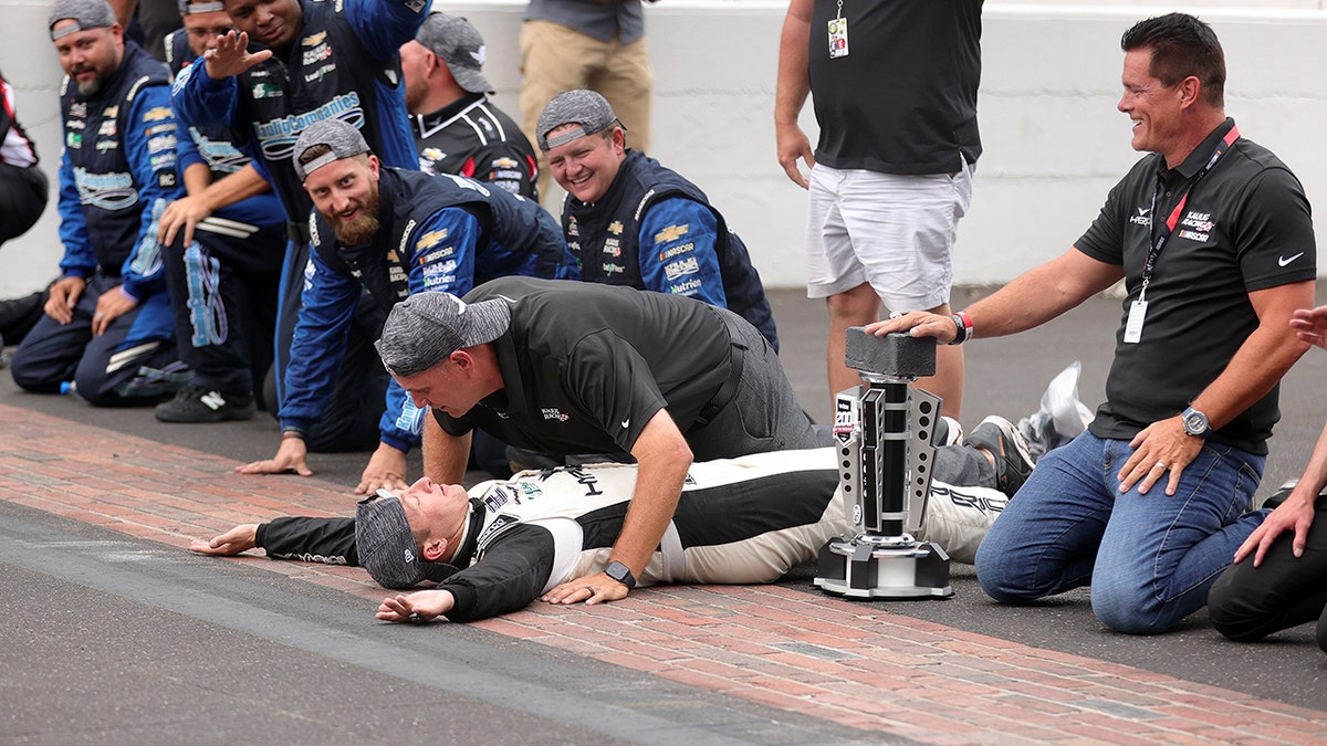 AJ Allmendinger, driver celebrates with his team on Indy's Yard of Bricks.