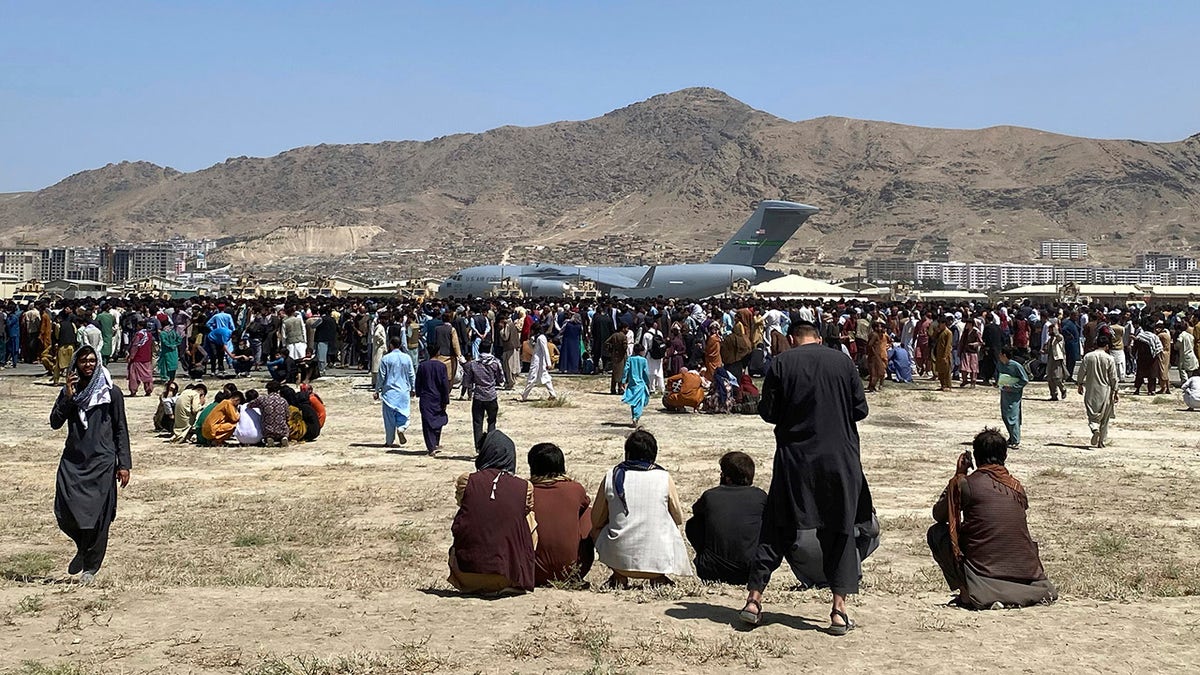 Hundreds of people gather near a U.S. Air Force C-17 transport plane at a perimeter at the international airport in Kabul, Afghanistan, on Monday.?