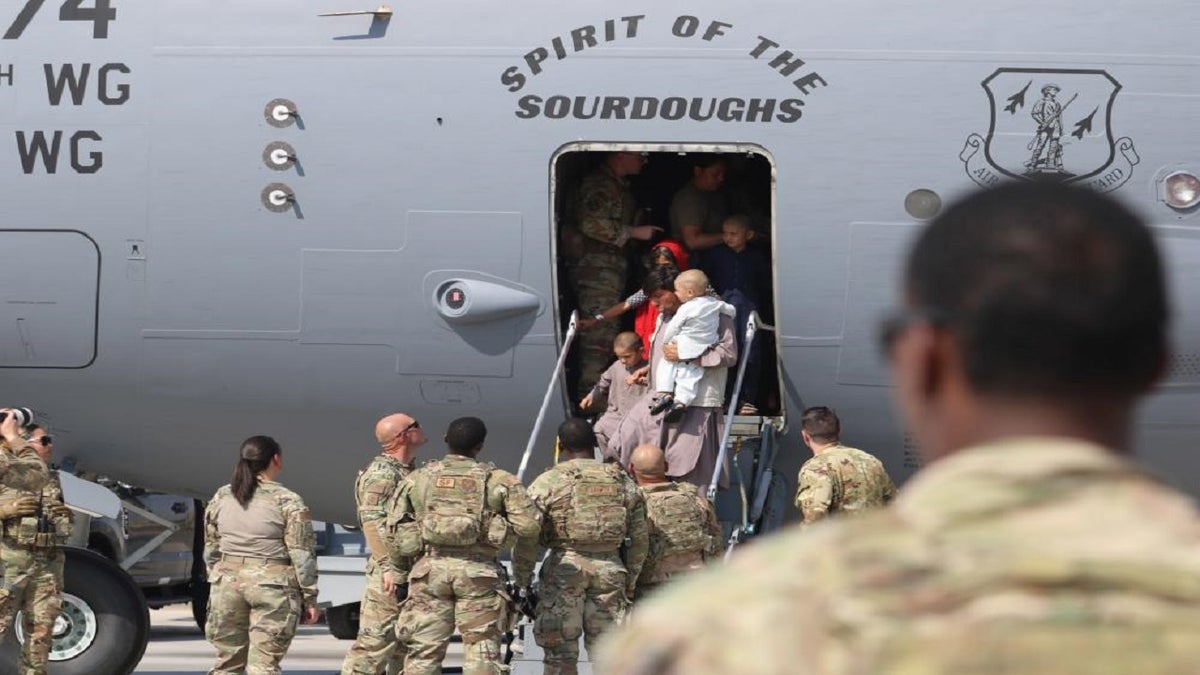 U.S. Air Force Airmen welcome Afghanistan evacuees arriving at Ali Al Salem Air Base in Kuwait on Monday. (U.S. Army Photo by 1st Lt. James Mason/DVIDS)