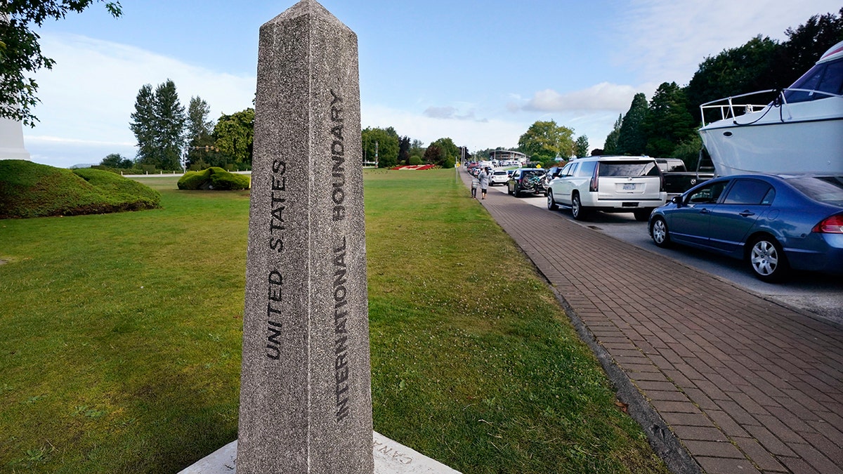 A line of vehicles wait to enter Canada at the Peace Arch border crossing Monday, Aug. 9, 2021, in Blaine, Wash. Canada lifted its prohibition on Americans crossing the border to shop, vacation or visit, but America kept similar restrictions in place, part of a bumpy return to normalcy from coronavirus travel bans. (AP Photo/Elaine Thompson)