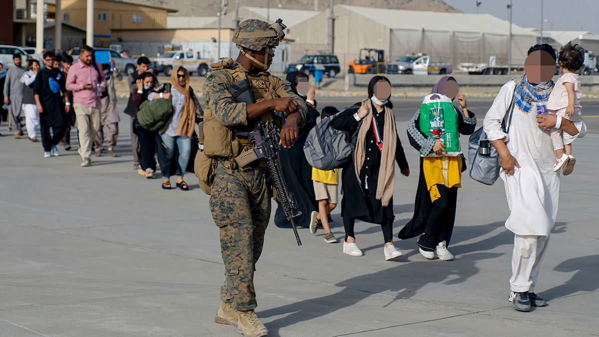 U.S. Marines assigned to 24th Marine Expeditionary Unit escorts evacuees during an evacuation at Hamid Karzai International Airport, Afghanistan, Aug. 18. (U.S. Marine Corps photo by Lance Cpl. Nicholas Guevara)