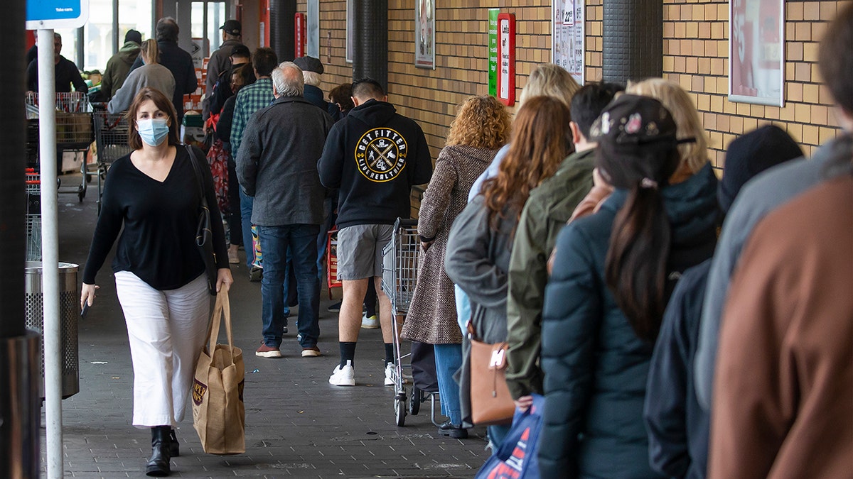 Shoppers lineup to enter a supermarket in Auckland, New Zealand, Tuesday, Aug. 17, 2021. New Zealand's government took drastic action Tuesday by putting the entire nation into a strict lockdown after detecting just a single community case of the coronavirus. (Brett Phibbs/New Zealand Herald via AP)