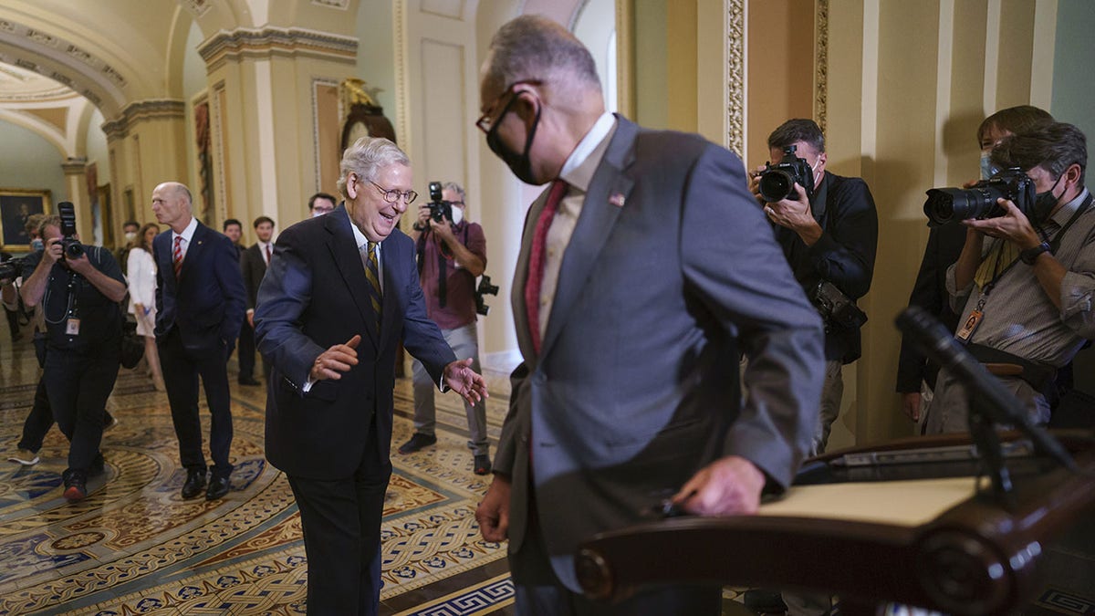 McConnell laughs at Schumer for beating him to the microphones at the Capitol.