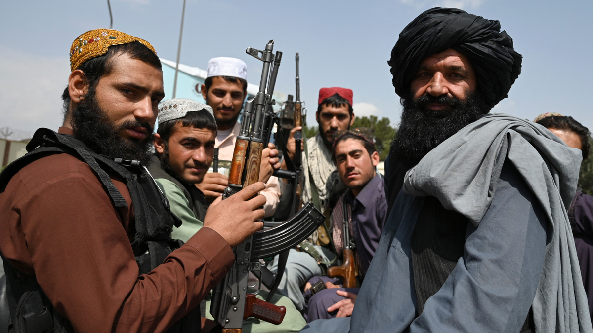 TOPSHOT - Taliban fighters sit on the back of a pick-up truck at the airport in Kabul on August 31, 2021, after the US has pulled all its troops out of the country to end a brutal 20-year war -- one that started and ended with the hardline Islamist in power.