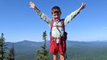 In this July 23, 2021, family photograph provided by Joshua Sutton, 5-year-old Harvey Sutton raises his arms on a mountain top in Bigelow Preserve, Maine, while hiking the Appalachian Trail with his Mom and Dad. Know by the trail name as "Little Man," Harvey tagged along with his parents over more than 2,100 miles over 209 days to complete the family feat. (Joshua Sutton via AP)