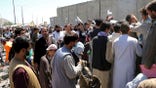 Hundreds of people, some holding documents, gather near an evacuation control checkpoint on the perimeter of the Hamid Karzai International Airport, in Kabul, Afghanistan, Thursday, Aug. 26, 2021. Western nations warned Thursday of a possible attack on Kabul's airport, where thousands have flocked as they try to flee Taliban-controlled Afghanistan in the waning days of a massive airlift. (AP Photo/Wali Sabawoon)