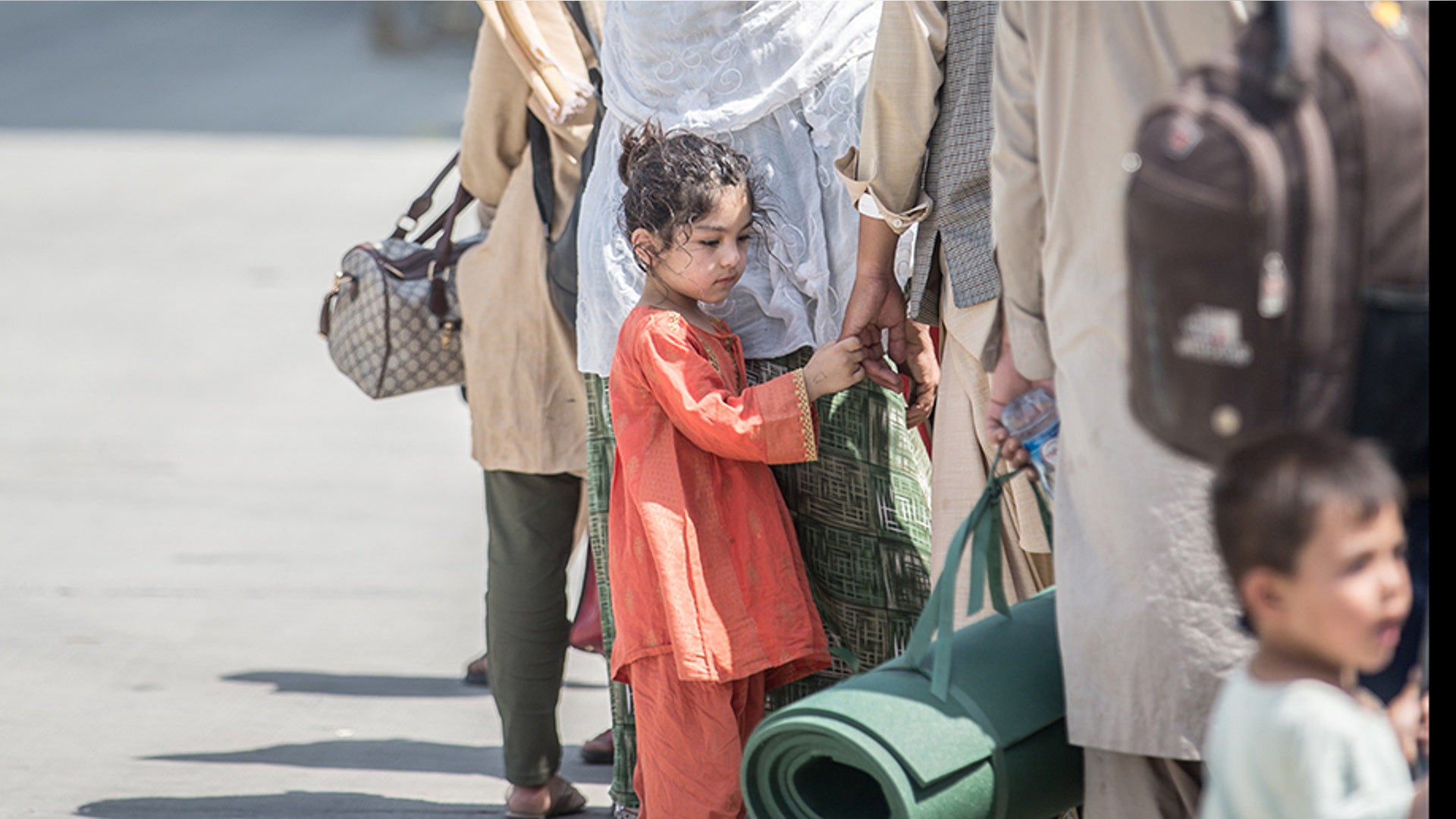 Families wait to board a U.S. Air Force Boeing C-17 Globemaster III during an evacuation at Hamid Karzai International Airport, Kabul, Afghanistan, Aug. 22. U.S. service members are assisting the Department of State with an orderly drawdown of designated personnel in Afghanistan. (U.S. Marine Corps photo by Sgt. Samuel Ruiz).