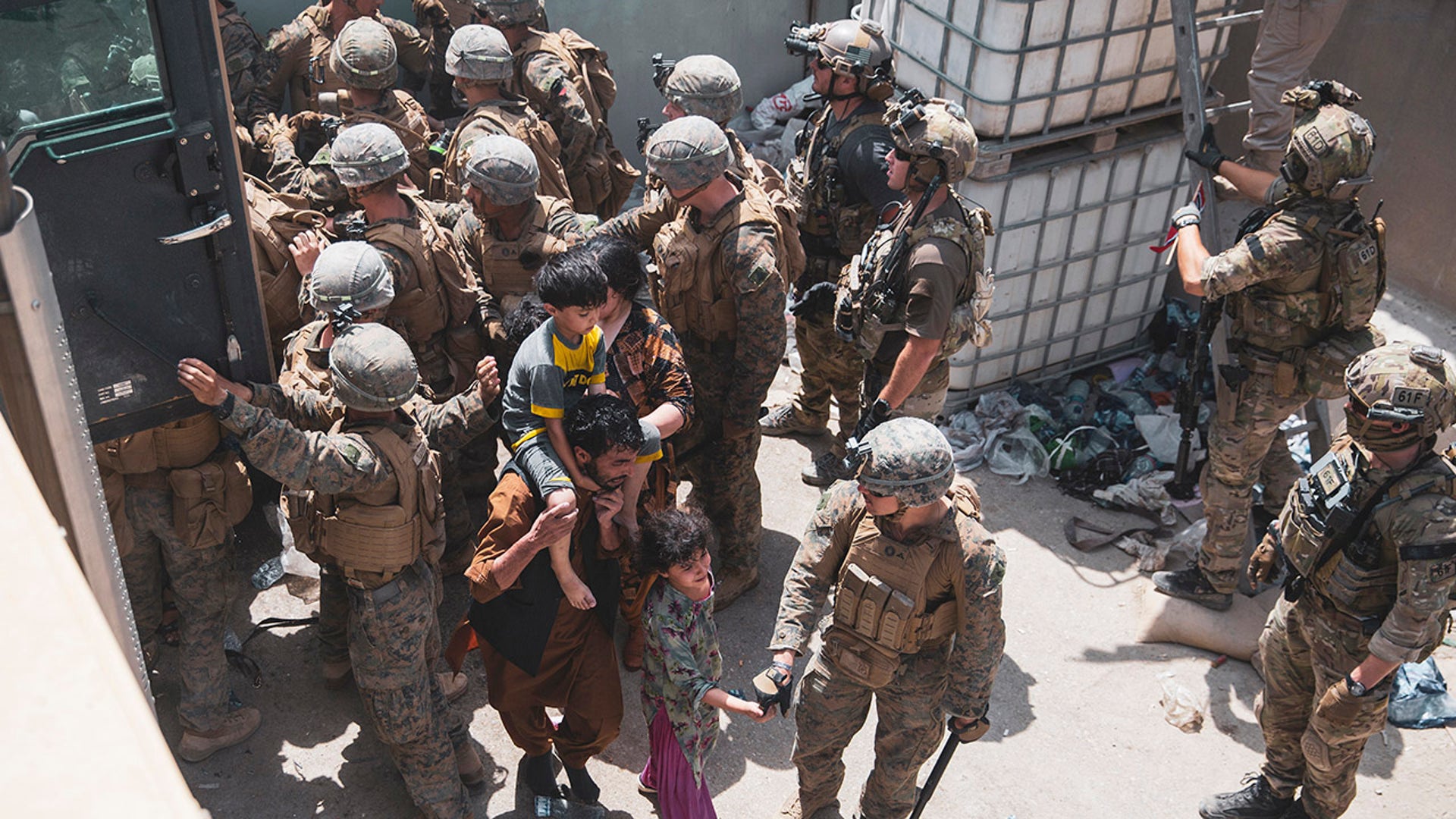 In this Aug. 20, 2021, photo provided by the U.S. Marine Corps, U.S. Marines and Norweigian coalition forces assist with security at an Evacuation Control Checkpoint ensuring evacuees are processed safely during an evacuation at Hamid Karzai International Airport in Kabul, Afghanistan. (Staff Sgt. Victor Mancilla/U.S. Marine Corps via AP)
