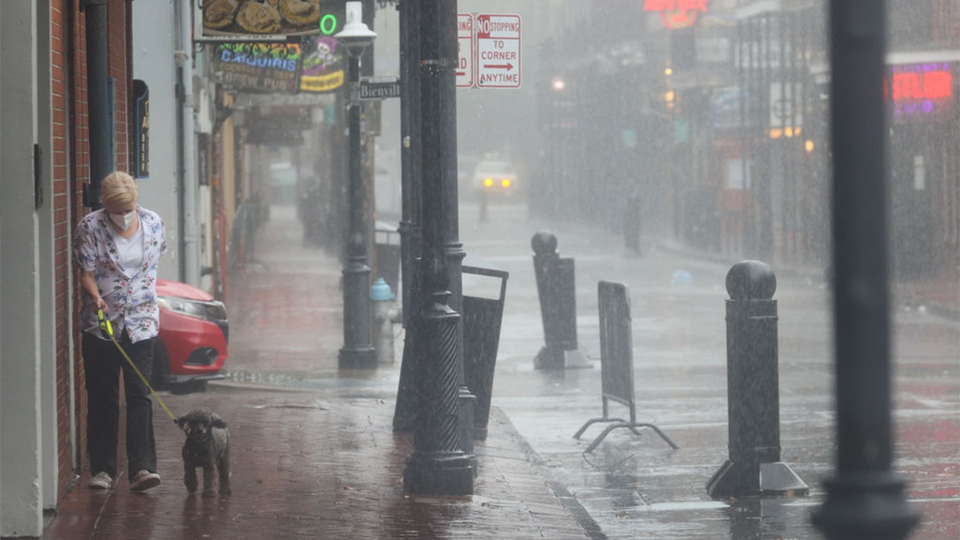NEW ORLEANS, LOUISIANA - AUGUST 29: A woman walks her dog in the French Quarter during Hurricane Ida on August 29, 2021 in New Orleans, Louisiana. Ida made landfall earlier today southwest of New Orleans.  (Photo by Scott Olson/Getty Images)