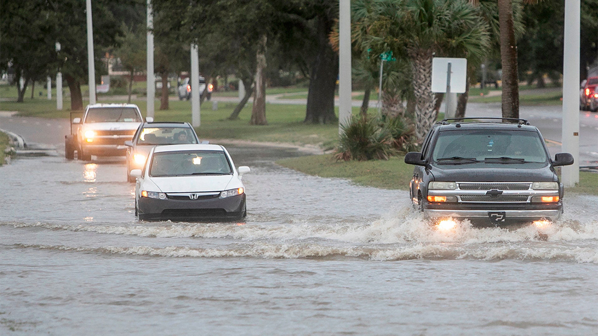 Vehicles drive through Hurricane Ida storm surge floodwater at U.S. 90 and Miramar Avenue in Biloxi, Miss., Sunday, Aug. 29, 2021. The Honda Civic, stalled out in the middle of the street as it tried to drive through the water. (Justin Mitchell/The Sun Herald via AP)
