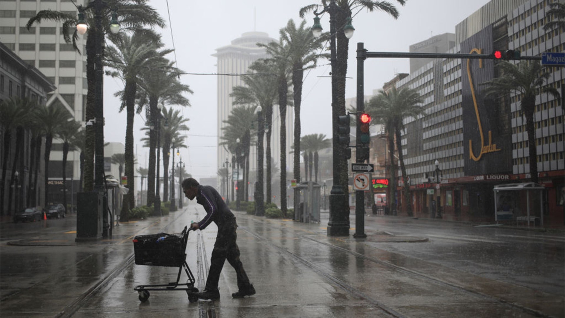 A pedestrian walks across Canal Street as Hurricane Ida makes landfall in New Orleans, Louisiana, U.S., on Sunday, Aug. 29, 2021. Hurricane Ida barreled into the Louisiana coast on Sunday, packing winds more powerful than Hurricane Katrina and a devastating storm surge that threatens to inundate New Orleans with mass flooding, power outages and destruction. Photographer: Luke Sharrett/Bloomberg via Getty Images