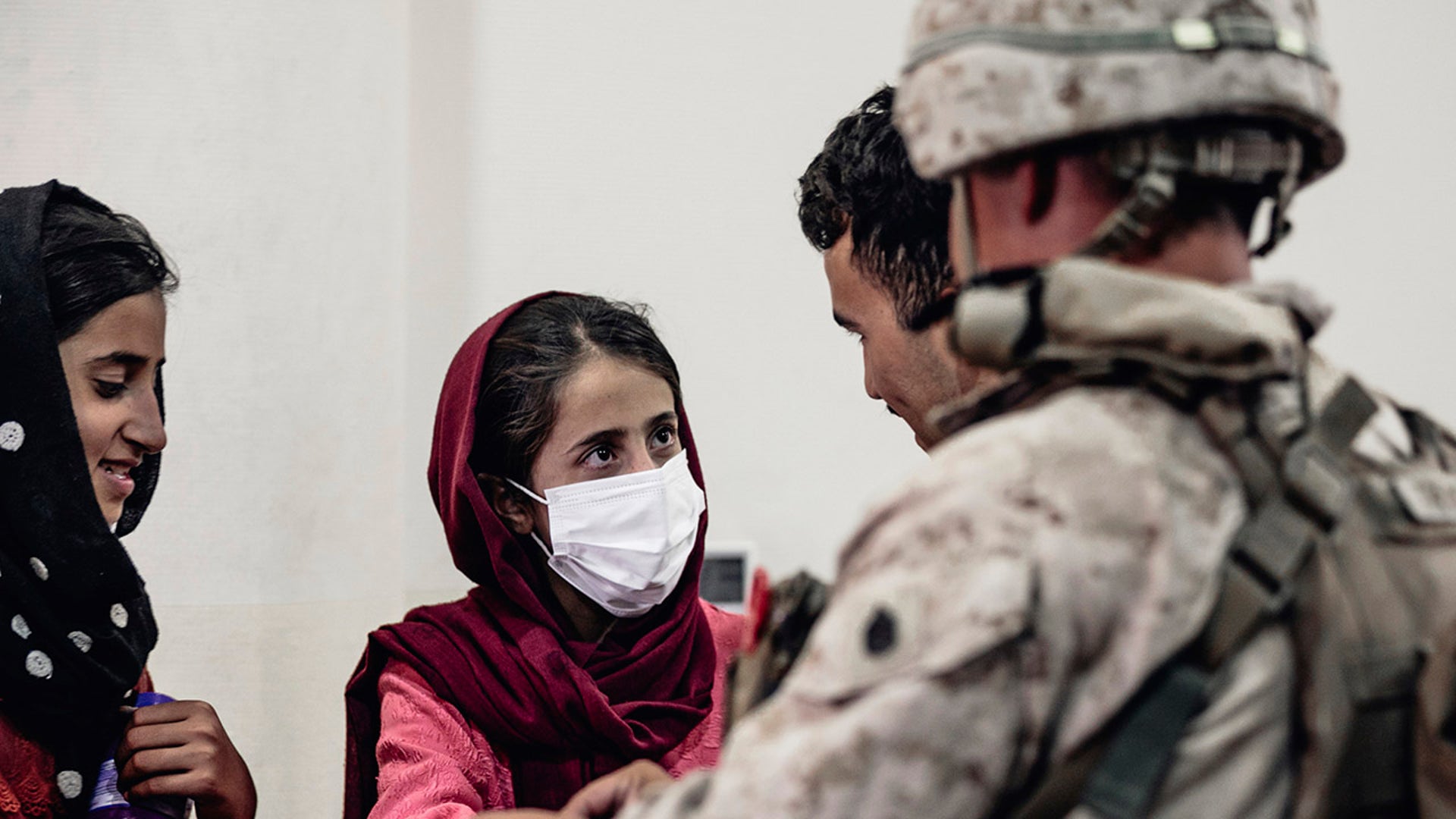 In this image provided by the U.S. Marine Corps, a Marine processes youth to be evacuated, at Hamid Karzai International Airport, Monday, Aug. 23. (Gunnery Sgt. Melissa Marnell/U.S. Marine Corps via AP)