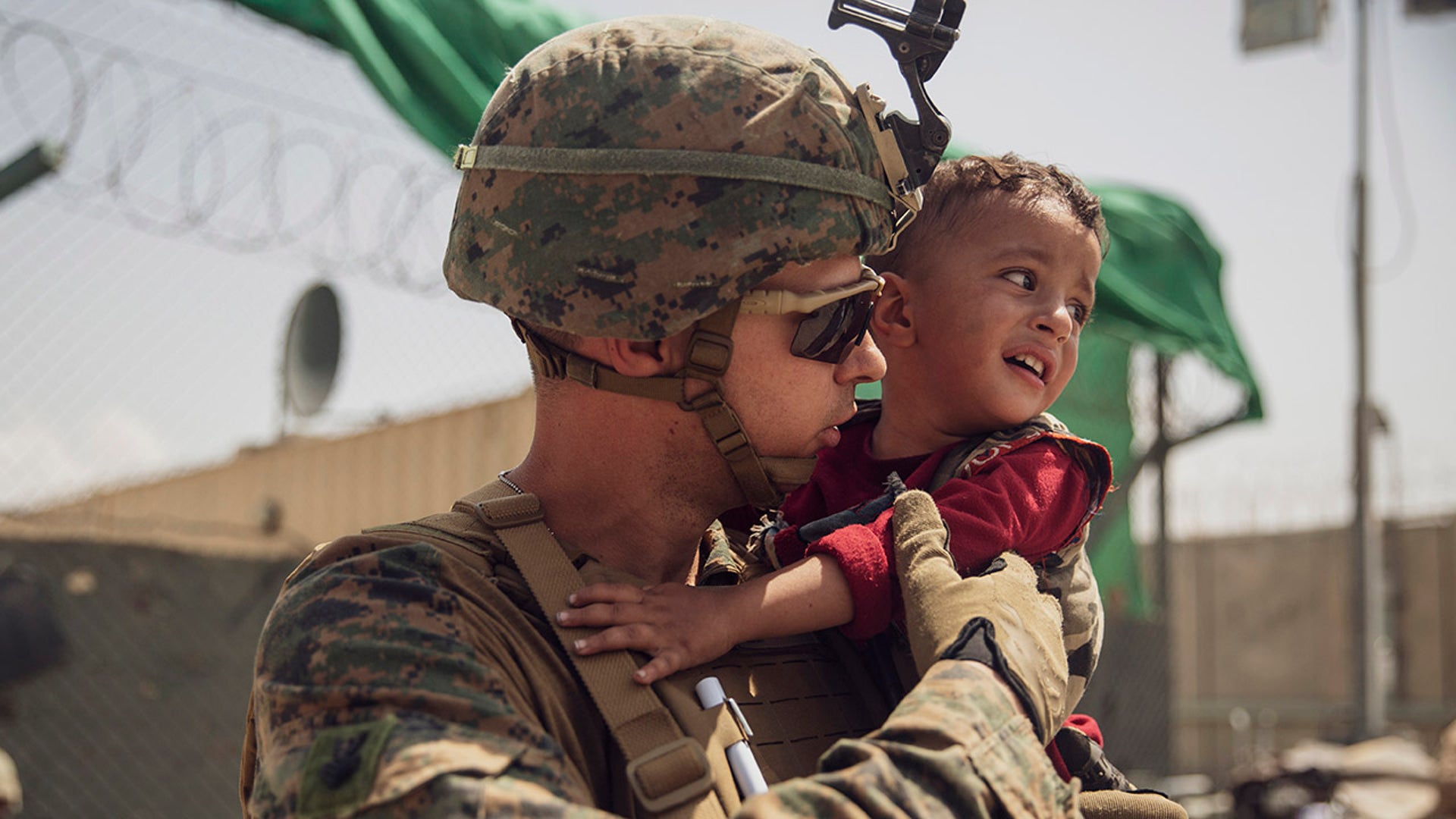 In this photo provided by the U.S. Marine Corps, a U.S. Marine with the 24th Marine Expeditionary Unit calms a crying toddler during an evacuation at Hamid Karzai International Airport, Kabul, Afghanistan, Sunday, Aug. 22, 2021. (Staff Sgt. Victor Mancilla/U.S. Marine Corps via AP)