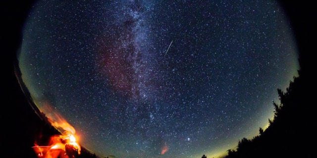 In this 30 second exposure taken with a circular fish-eye lens, a meteor streaks across the sky during the annual Perseid meteor shower on Friday, Aug. 12, 2016 in Spruce Knob, West Virginia.